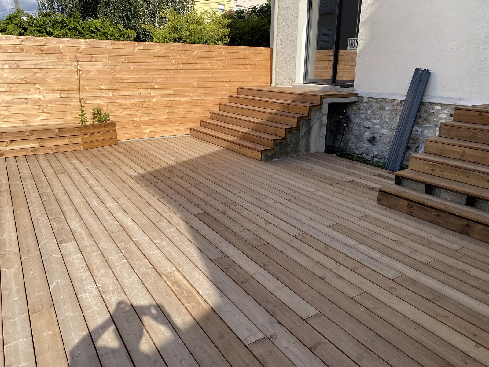 Vue large de la terrasse en pin traité avec bancs et brise-vue, Noisy-le-Grand
