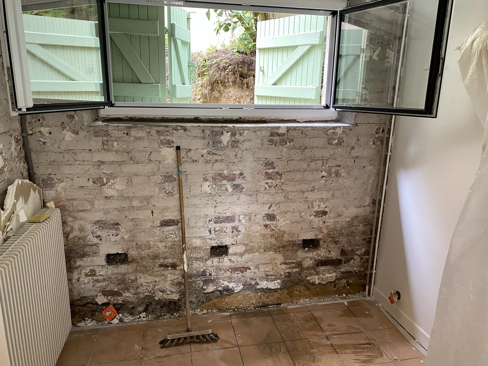 Mur en brique décapé et humide, côté cuisine, maison à Sèvres