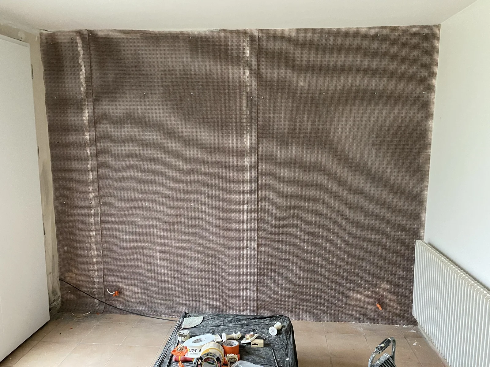 Pose de la nappe drainante DELTA-PT sur le mur humide