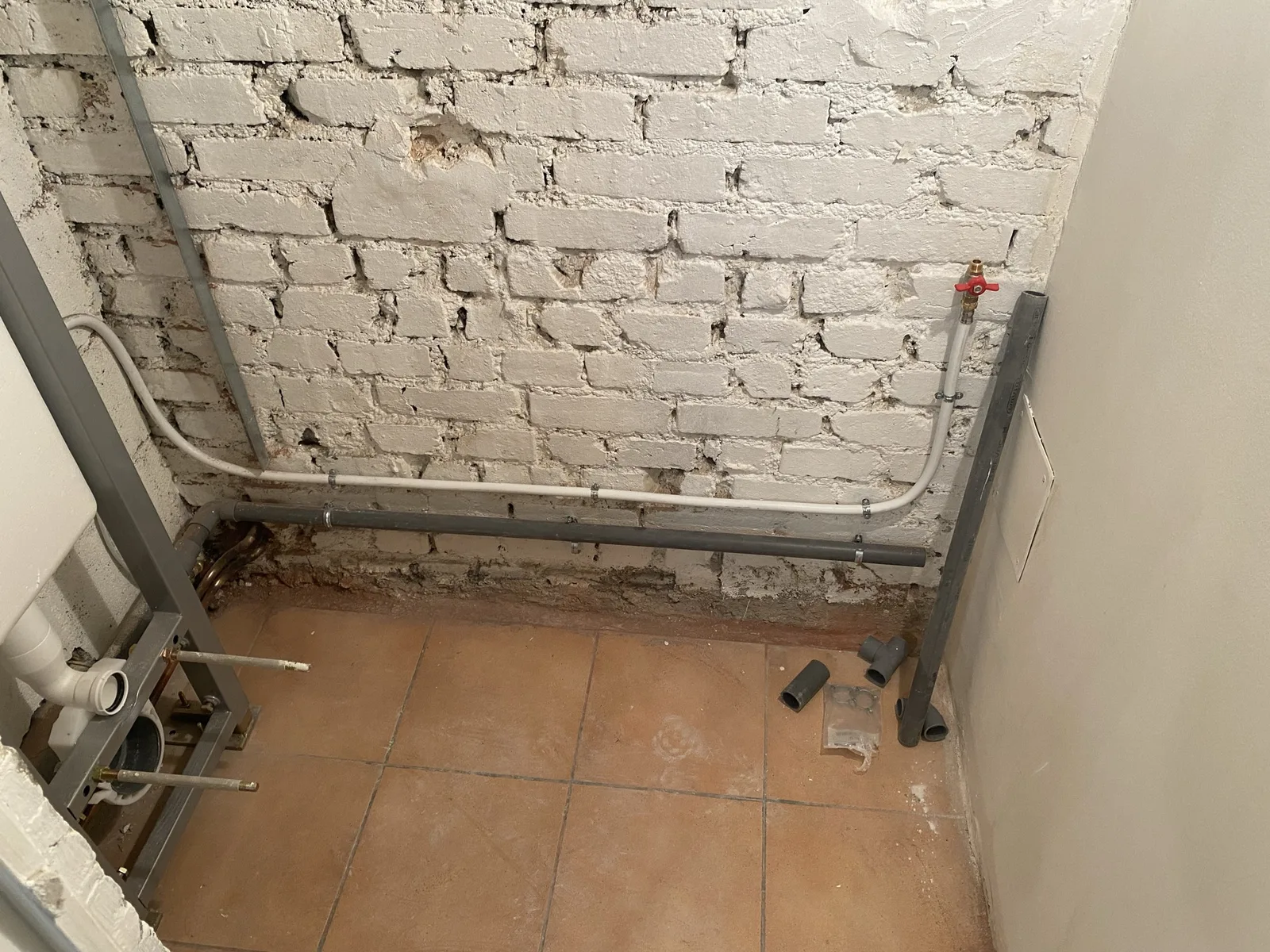 Réseaux d'alimentation et d'évacuation en place, mur en brique conservé et peint, Sèvres